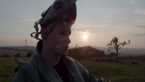 portrait of a man in an anti-chemical military suit taking off his gas mask