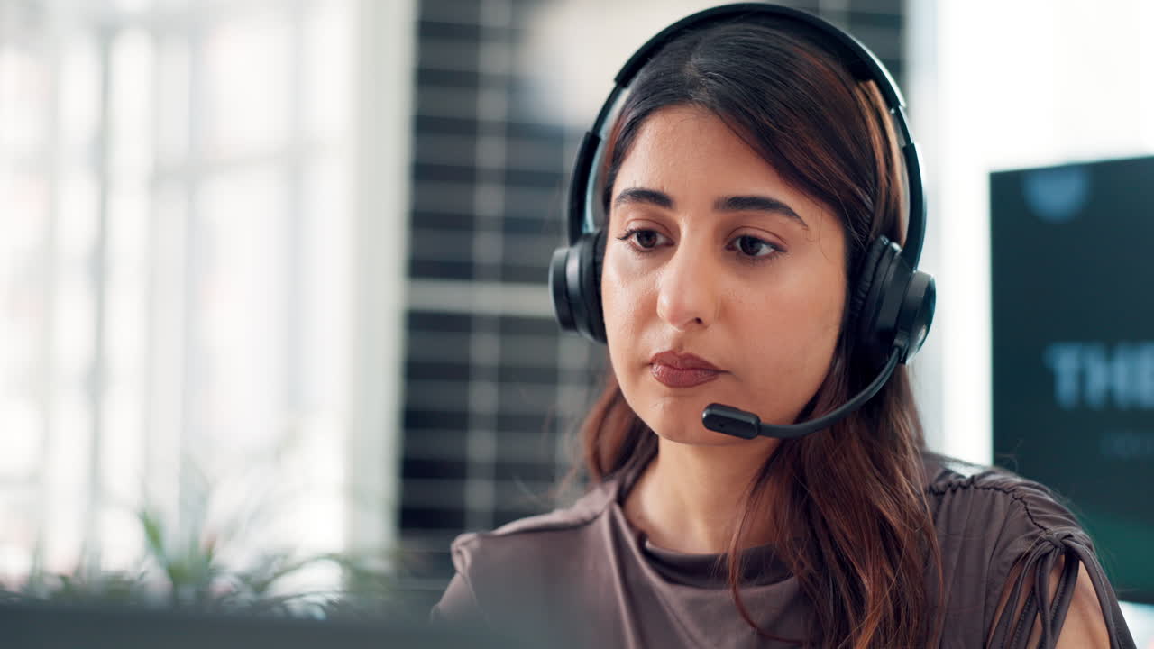 Giovane donna con cuffie che parla in un ufficio di call center