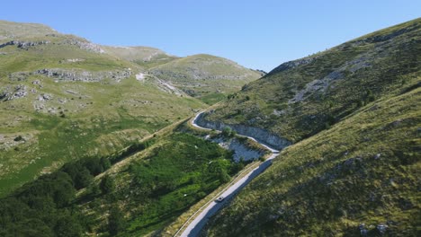 Toma-Estática-De-Un-Jeep-Viajando-Por-Estrechos-Caminos-De-Montaña-Debajo-Del-Pico.