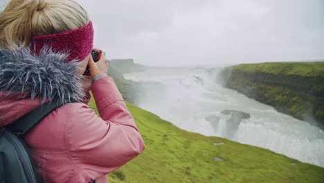 tourist woman looking at gullfoss waterfall the famous attraction and landmark destination on iceland on the golden circle