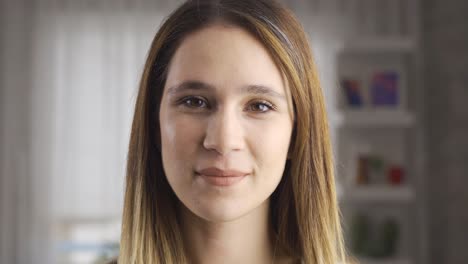 mujer en casa mirando a la cámara y sonriendo.