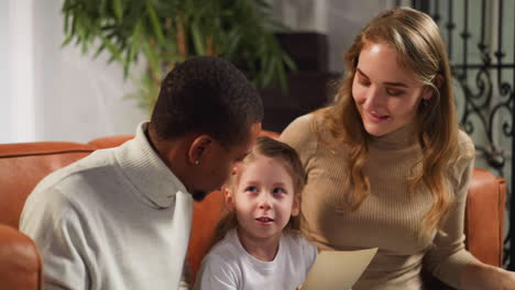 mother and father show picture of grandfather to little girl