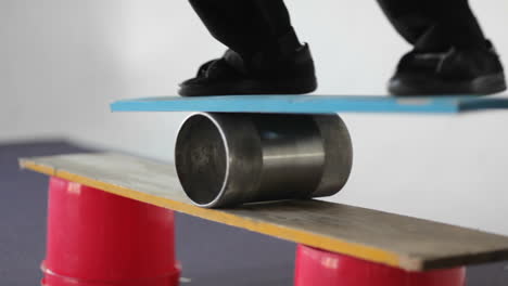 a man balances on a board set on top of a roller