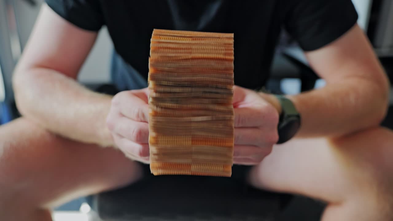 Slow motion shot of euro banknotes turning in hands indoors, fragile economy