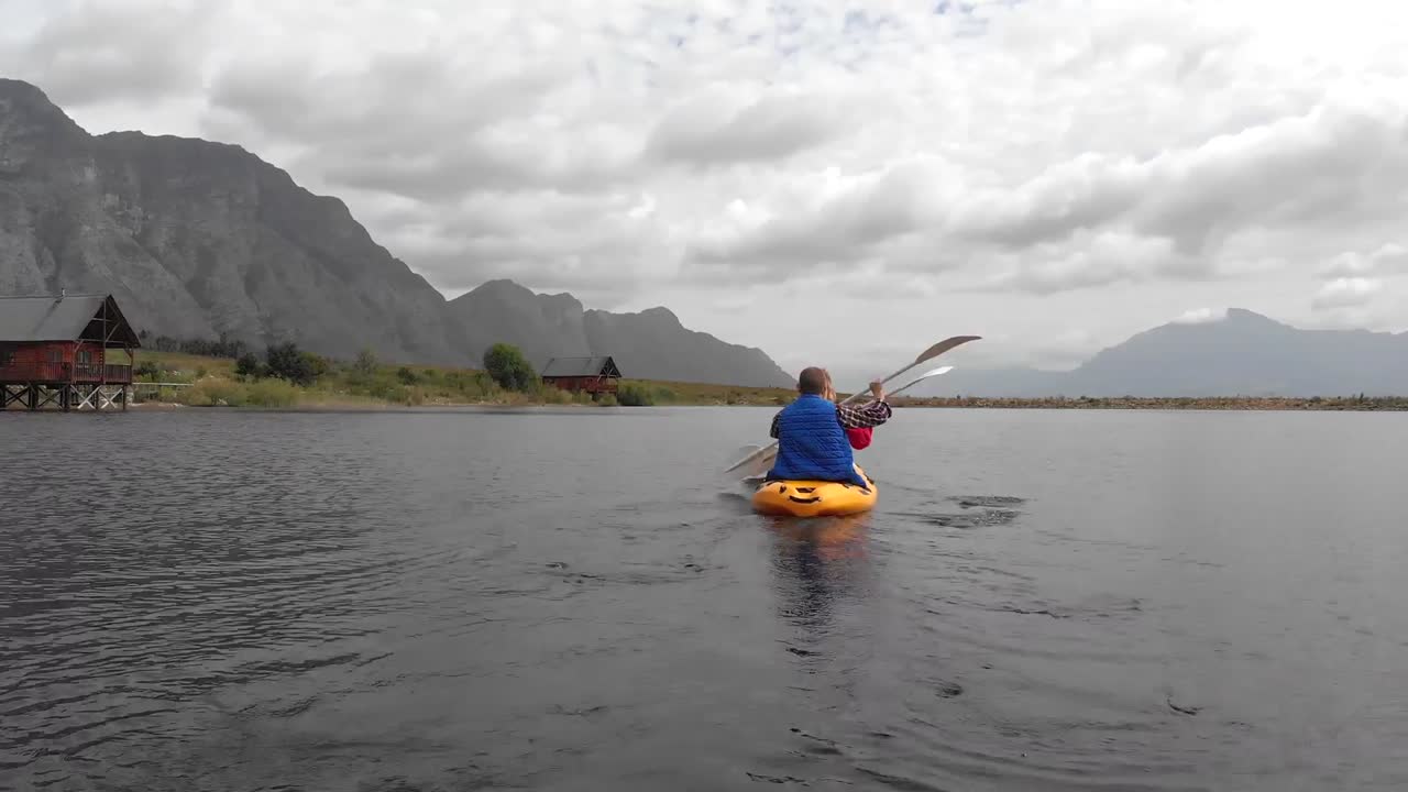 animación de personas caucásicas que se quejan en una canoa amarilla, montañas y nubes blancas