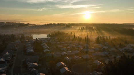 Luftaufnahme-Der-Sonne,-Die-über-Einer-Bereiften-Nachbarschaft-Mit-Morgennebel-Aufgeht