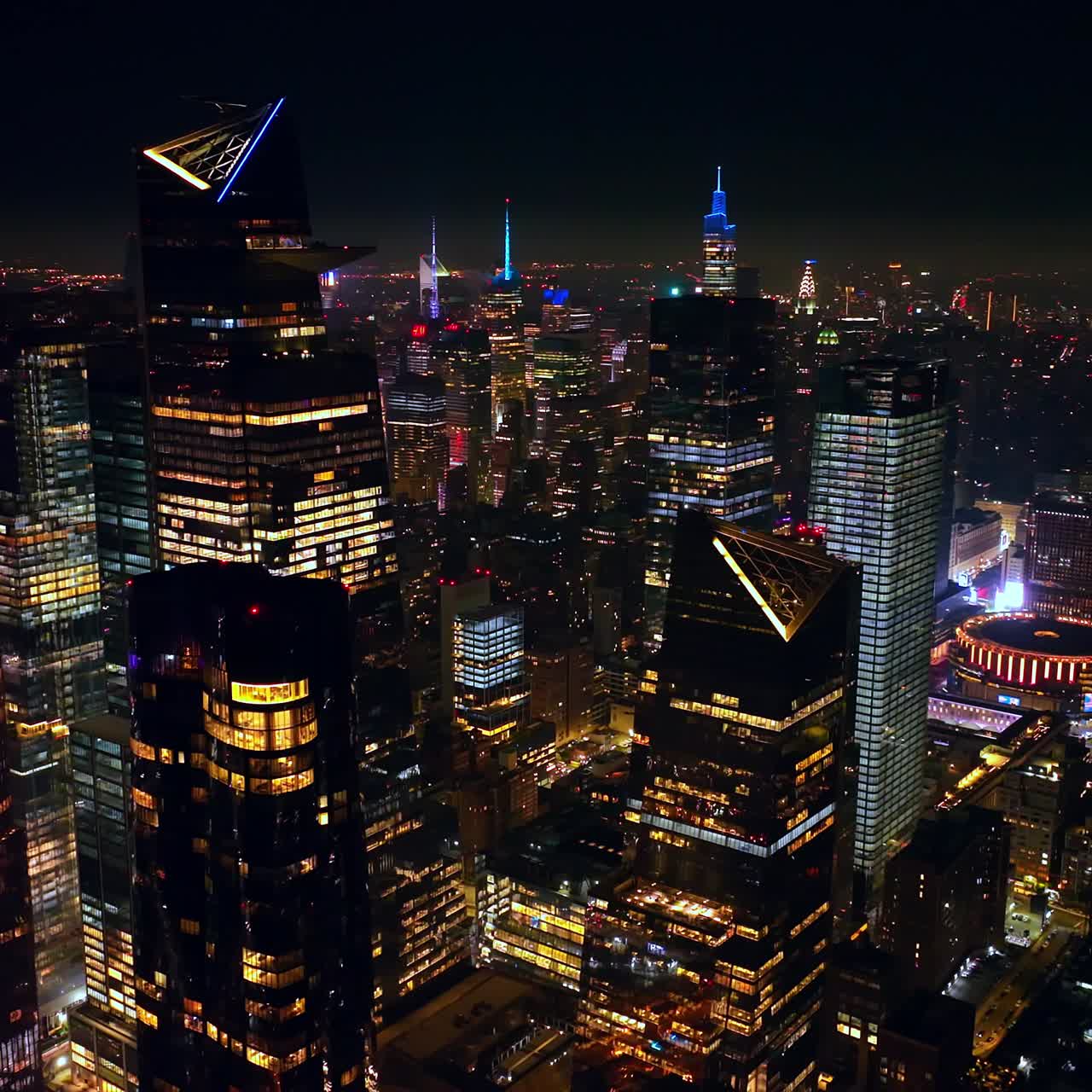 Multiple lights reflecting in the mirror windows of famous New York skyscrapers. Endless cityscape of stunning metropolis. Aerial view