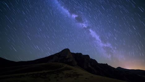 star trails and milky way over mountain landscape