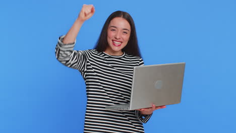 joven feliz trabajando en una computadora portátil ganando un juego de lotería en línea celebrando el éxito victoria