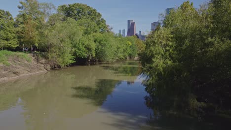 reveal of houston skyline from buffalo bayou park river on a sunny day