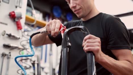 Mecánico-Anónimo-Limpiando-Horquilla-De-Bicicleta-Con-Pistola-De-Aire