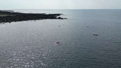 drone aerial view in south korea countryside flying over the sea rocky area shallow area big building haenyeo women divers fishing jeju island