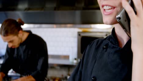 chef looking at clipboard while talking on mobile phone 4k