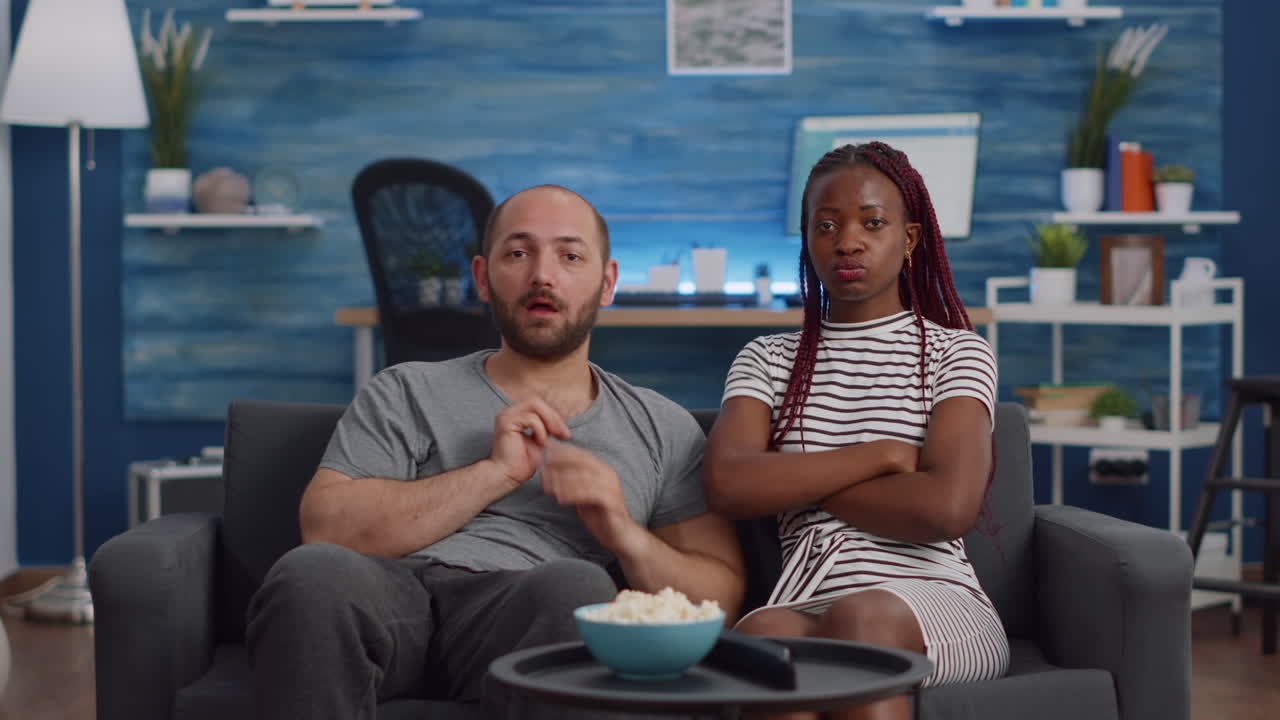 POV of interracial couple being shocked watching television