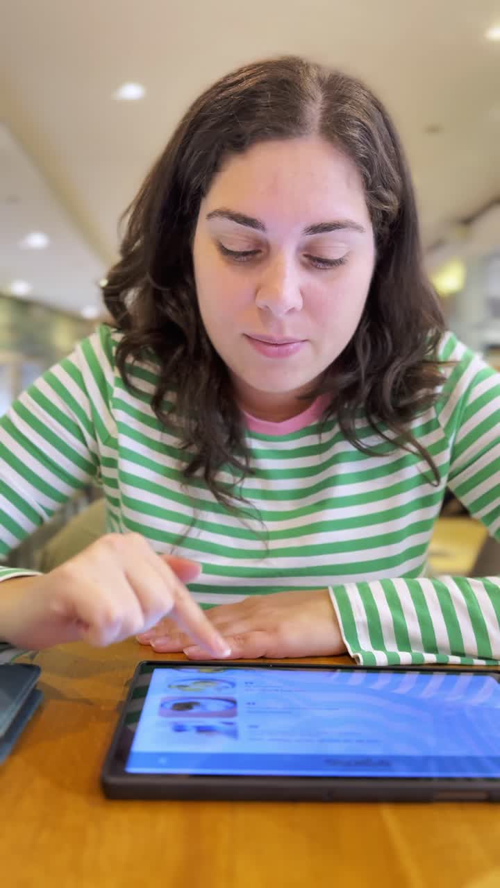Woman ordering food on tablet in coffee shop