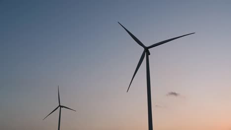 wind turbines silhouette against the blue-sky during sunset, clean alternative energy in thailand and mainland southeast asia