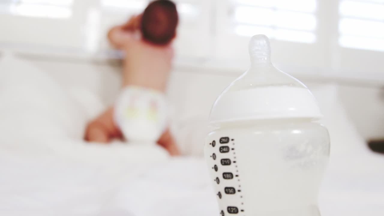Primo piano su un biberon con il bambino sullo sfondo