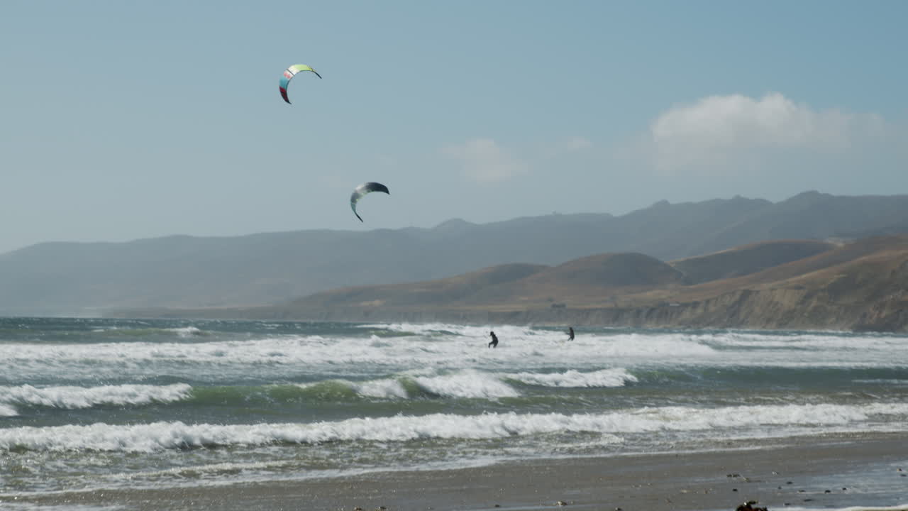 Friends kiteboarding ion the ocean off the California coast