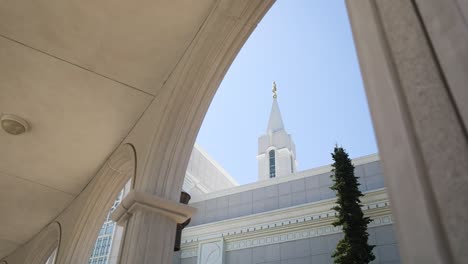 Weitwinkelaufnahme-Unter-Dem-üppigen-Bogen-Des-Utah-Tempels-Mit-Der-Engel-Moroni-Statue-Auf-Der-Spitze