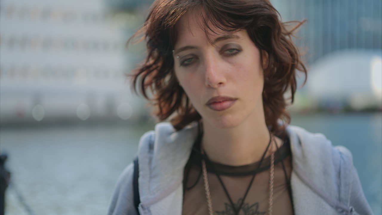 retrato de moda al aire libre de una joven de estilo alternativo con tatuajes y perforaciones en canary wharf en los muelles de londres, filmado en tiempo real.