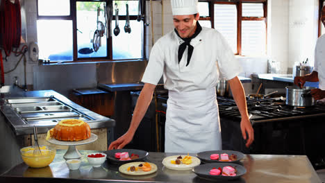 Smiling-chef-leaning-on-dessert-counter