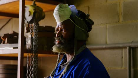 thoughtful worker standing in foundry workshop 4k