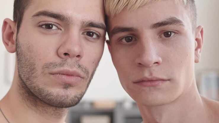 Portræt af to unge homoseksuelle mænd, der kigger ind i kameraet