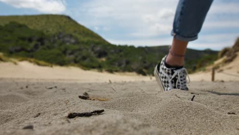 una joven camina sobre la cálida arena de la playa de mallorca