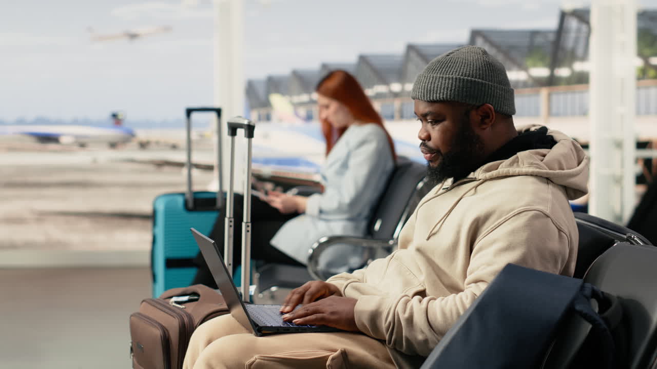 African American Man Working on Laptop in Airport Waiting Area
