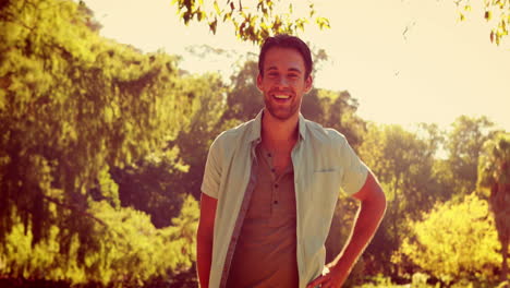 hombre guapo sonriendo a la cámara en el parque