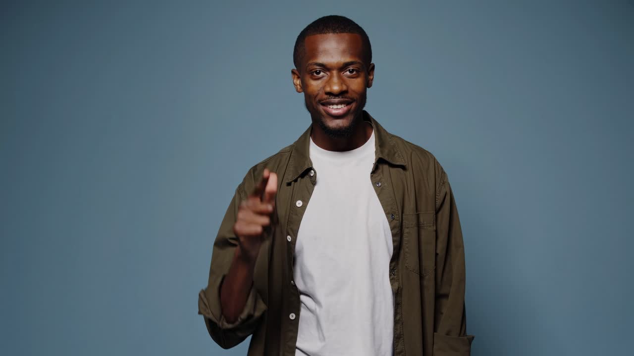 amigable modelo masculino adulto señalando con el dedo índice mostrando varias direcciones, arriba, abajo, izquierda, derecha, sonriendo y expresando emociones positivas, aislado en un fondo azul sin costuras