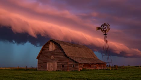 breathtaking rustic barn amidst dramatic storm clouds and windmill: a stunning display of nature's power and tranquility in the open fields