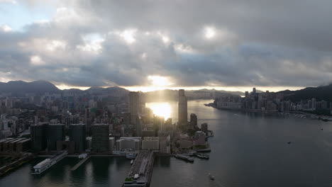 Sun-rays-through-the-clouds,-behind-Tsim-Sha-Tsui-in-Hongkong-on-a-cloudy-day