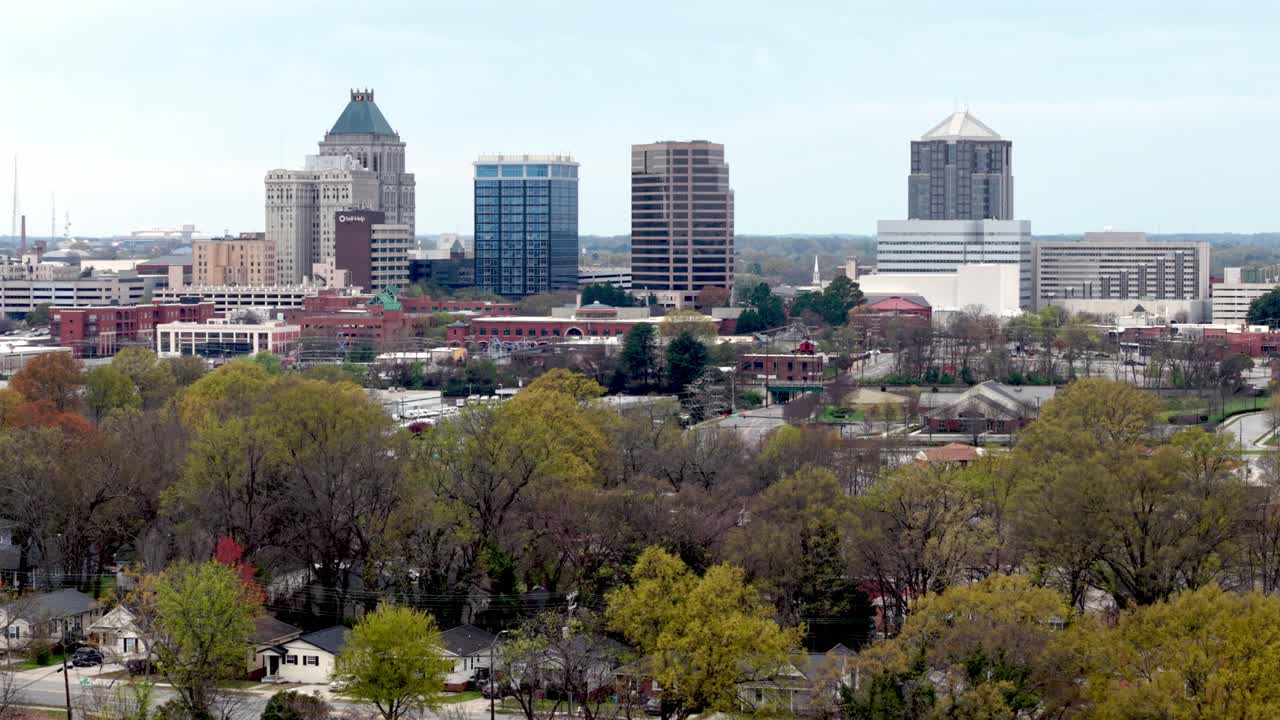 Ripresa aerea in allontanamento dallo skyline di Greensboro, Carolina del Nord, in primavera