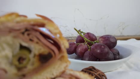 close-up of sliced savory bread and grapes with festive lights in the background