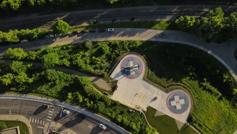 Medical-helicopter-on-landing-pad-near-hospital,-aerial-top-down-view