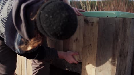 skilled man making diy hot tub screwing wood planks as a frame box