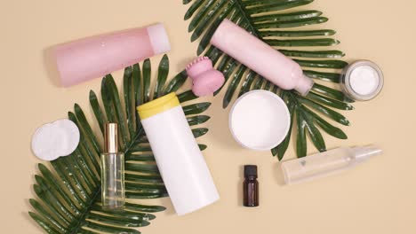 spa wellness skin care products with tropic palm leaves on beige background. stop motion flay lay