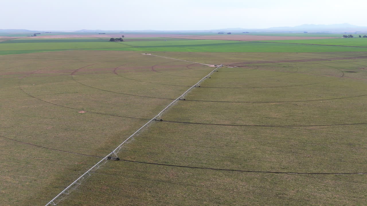 Aerial view of vast farmland with center pivot irrigation systems. Expansive agriculture.