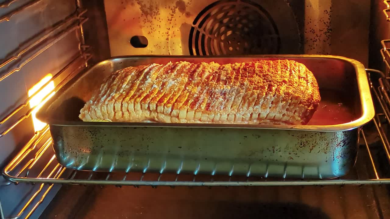 4K60 Sacando el cerdo asado con chicharrón del horno antes de cortar el asado.