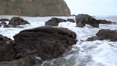 olas rompiendo entre muchas rocas