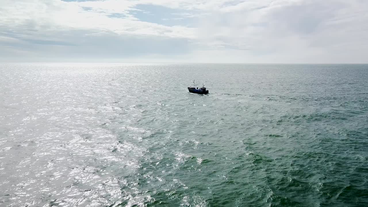 화창한 날에 잔잔한 발트해에서 항해하는 어선의 아름다운 공중 전망, 광각 드론 샷이 앞으로 이동