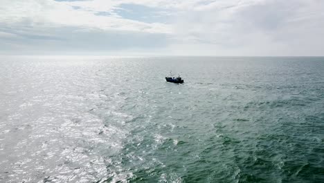 Beautiful-aerial-view-of-a-fishing-boat-sailing-in-the-calm-Baltic-sea-in-sunny-day,-wide-angle-drone-shot-moving-forward