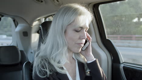 mujer hablando por telefono en un auto