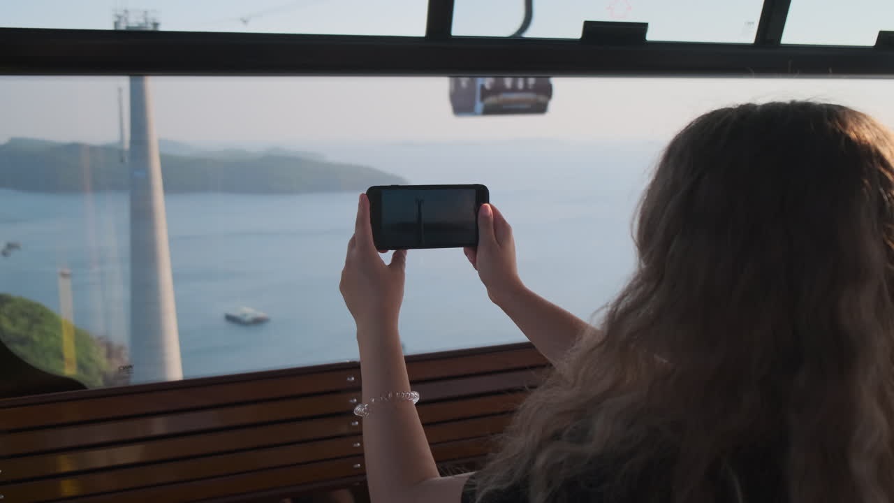 mujer tomando una foto de la vista panorámica desde el teleférico