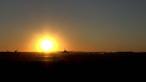 4k. commercial airplane is landing on the airport runway during sunset.