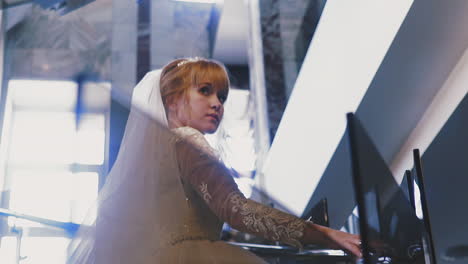 girl with veil and wonderful wedding dress goes up stairs