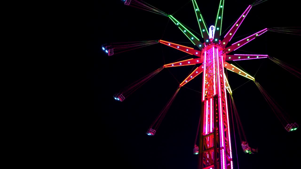 4k multicolor iluminado alto carrusel girando en el parque de atracciones