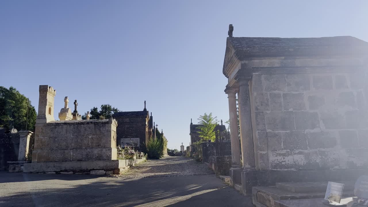 Antiguo cementerio histórico con grandes tumbas de piedra, pequeñas capillas y viejas lápidas, sin gente, en un país cálido y soleado de Europa.