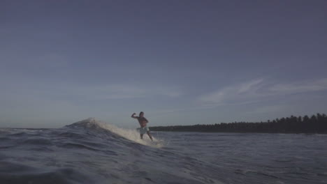 surfistas filipinos asiáticos disfrutando de pequeñas olas en un clima sombrío